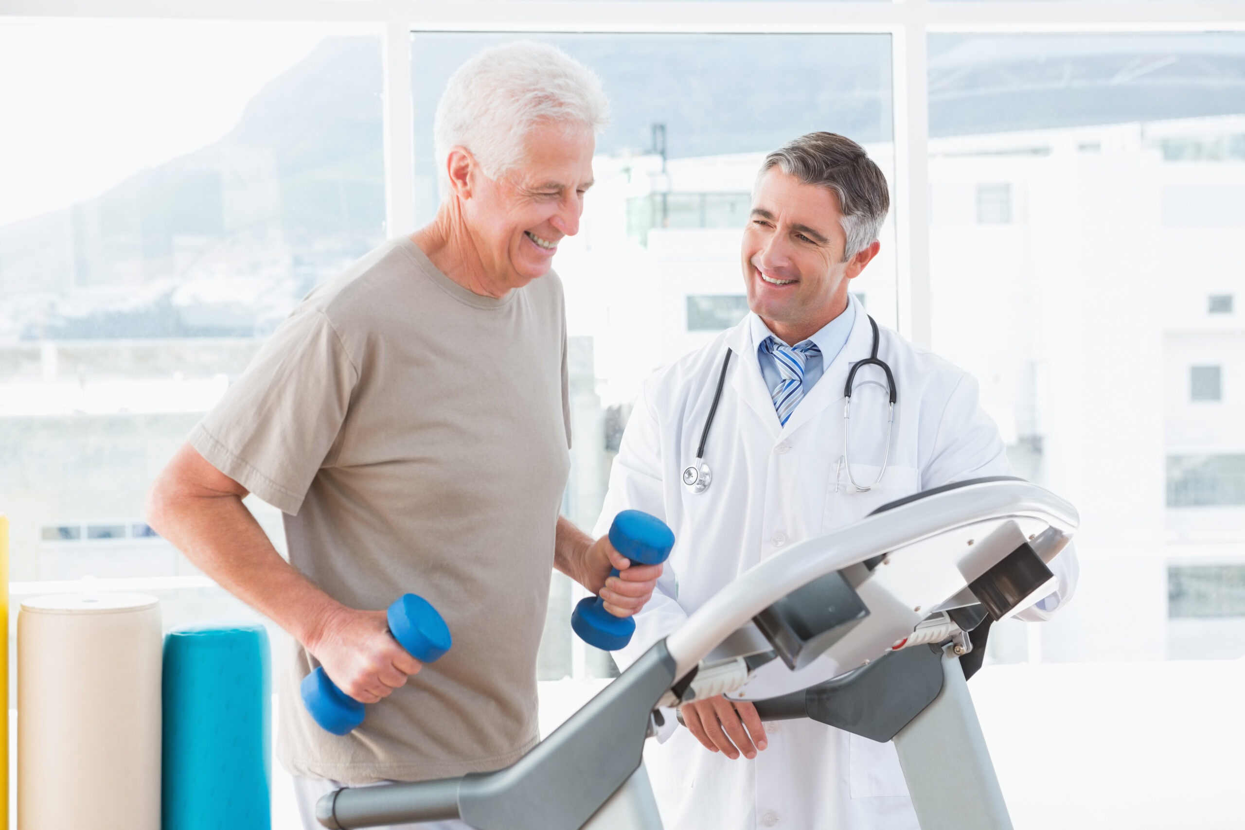 Senior man on treadmill with therapist